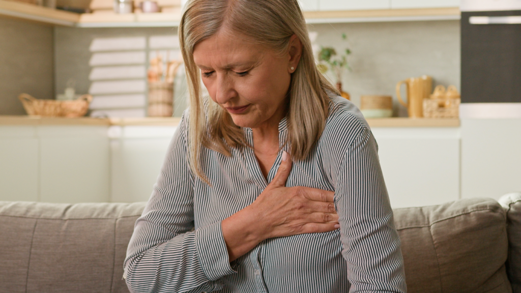 Mulher com dor no peito, preocupada com o coração acelerado sem motivo